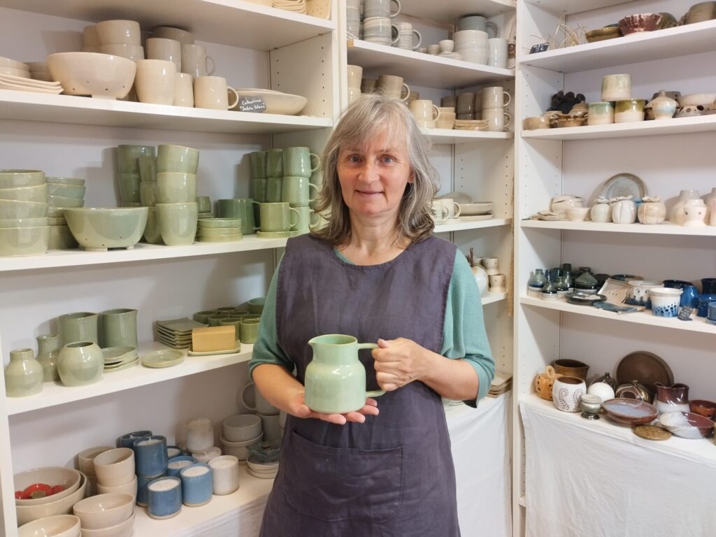 Sophie LEPLEE dans son atelier, devant ses céramiques artisanales
