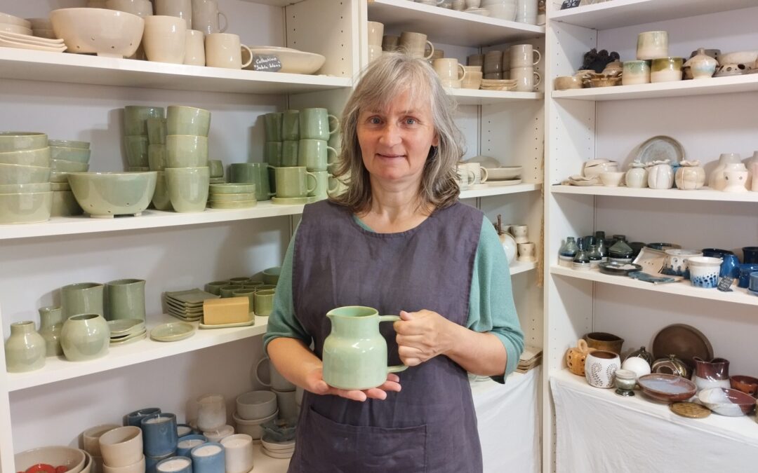 Sophie LEPLEE dans son atelier, devant ses céramiques artisanales