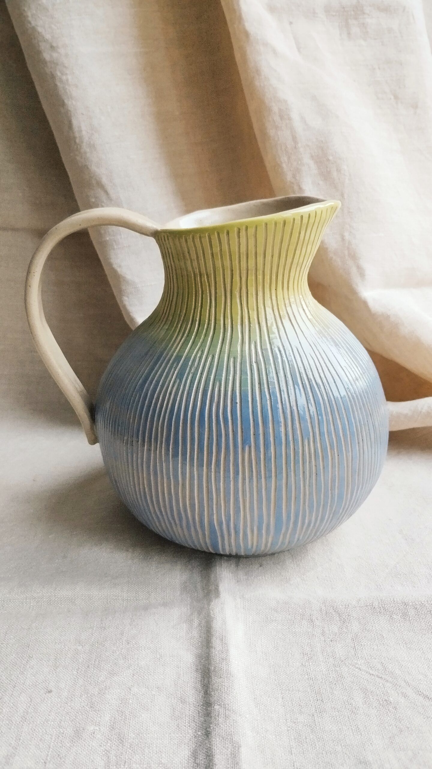 carafe Sillon figue. Céramique artisanale colorée en dégradé de mauve et vert. Motif de lignes verticales gravées