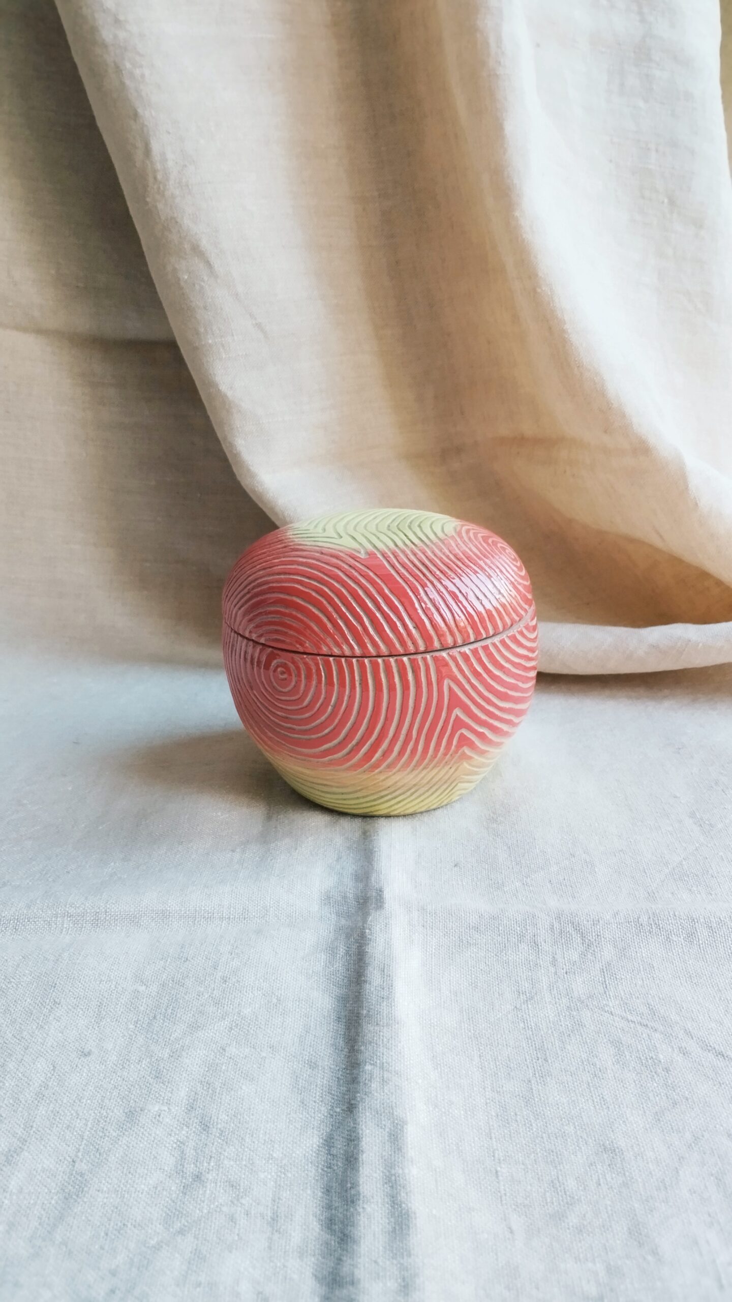 Boite Sillon pomme. Céramique artisanale colorée en dégradé de rouge et jaune. Motif de lignes concentriques gravées