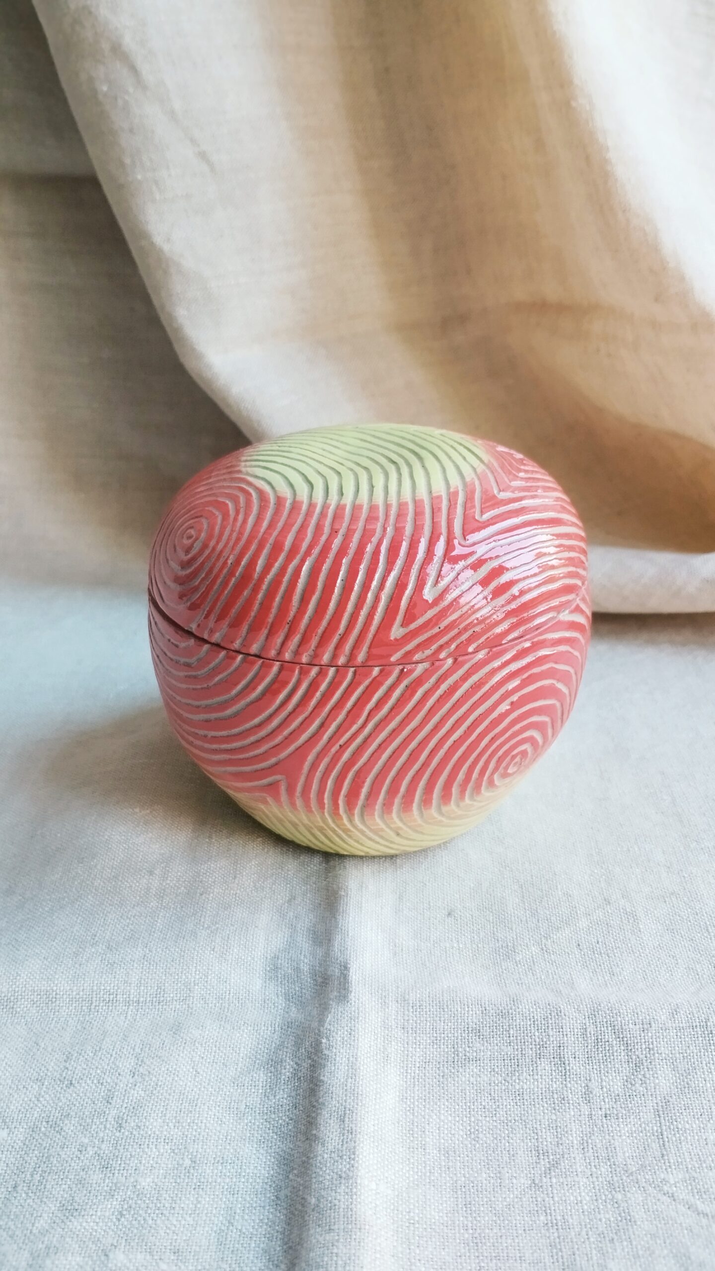 Boite Sillon pomme. Céramique artisanale colorée en dégradé de rouge et jaune. Motif de lignes concentriques gravées
