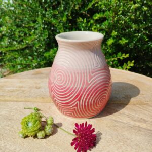 Vase "sillon" rouge et rose. Poterie artisanale. Céramique décorée en dégradé de rouge à rose. Motif de lignes gravées Vase "sillon" rouge et rose. Poterie artisanale. Céramique décorée en dégradé de rouge à rose. Motif de lignes gravées de cercles concentriques