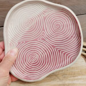 Plat décoratif en céramique, fond coloré en dégradé de rose, motif de lignes gravées de cercles concentriques